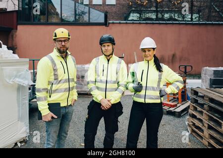 Portrait of male and female engineers standing together at construction site Stock Photo