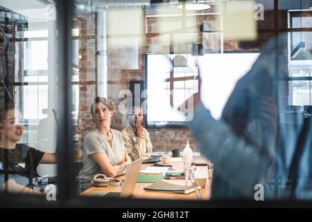 Male and female entrepreneurs discussing during meeting in board room Stock Photo