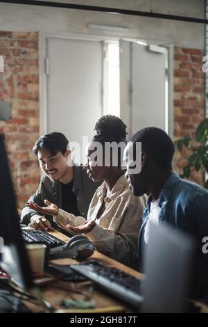 Female entrepreneur discussing with male colleague over computer in office Stock Photo