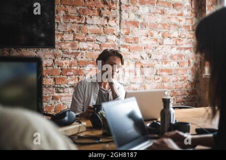 Female computer programmers working on laptop in startup company Stock Photo