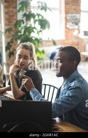 Male programmer explaining female colleague while working at office Stock Photo