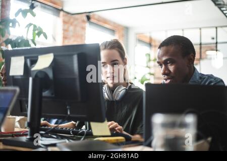 Female and male programmers coding on computer at office Stock Photo