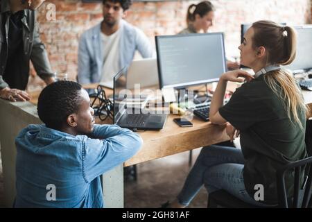 Male and female programmers coding over computer in office Stock Photo
