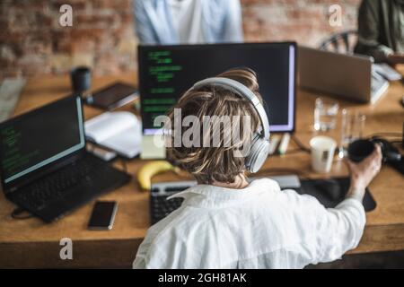 Female hacker working over computer at creative office Stock Photo