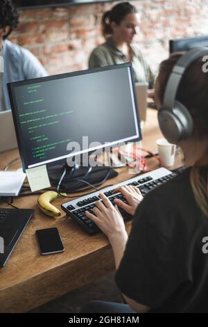 High angle view of female hacker coding over computer in office Stock Photo