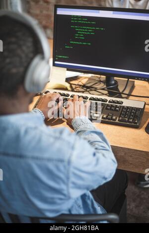 Male programmer coding over computer at startup company Stock Photo
