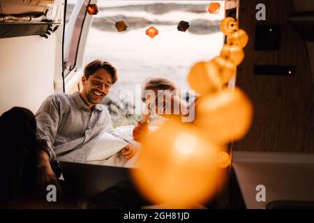 Happy gay couple using laptop in motor home during vacation Stock Photo