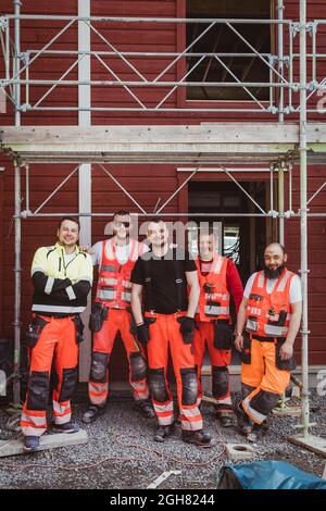 Full length of male construction workers standing together at site Stock Photo