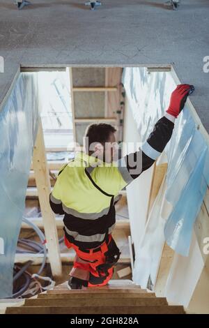 Male construction worker moving down steps while working at site Stock Photo