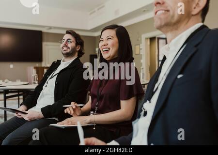 Business people laughing in discussion during meeting at education class Stock Photo