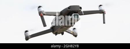 Silvery drone flies in sky. Drone aerial photography Stock Photo