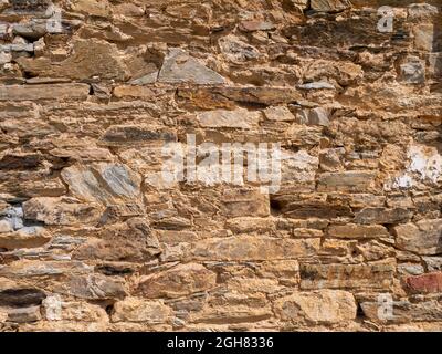 Natural bright yellow limestone wall sunny background with shadows Stock Photo