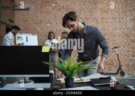 Young businessman standing and working in office, cooperation, presentation and brainstorming concept. Stock Photo