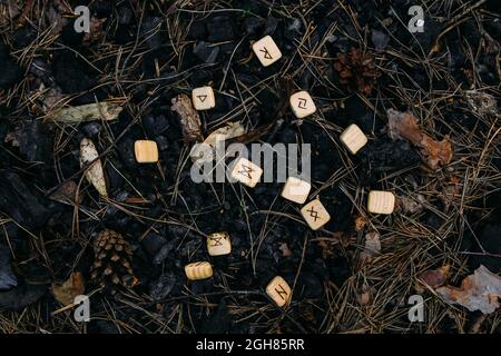 Runes scattered in old ashes. Occult, esoteric concept. Stock Photo