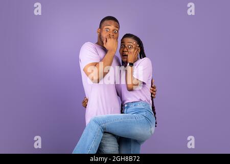 Scared African American couple covering mouth and eyes Stock Photo