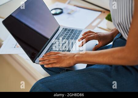 African American draftswoman typing on her laptop Stock Photo