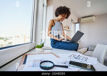 Joyous draftswoman working on the portable computer Stock Photo