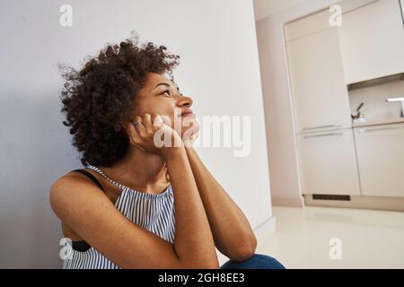 Smiling contented lady daydreaming on the floor Stock Photo