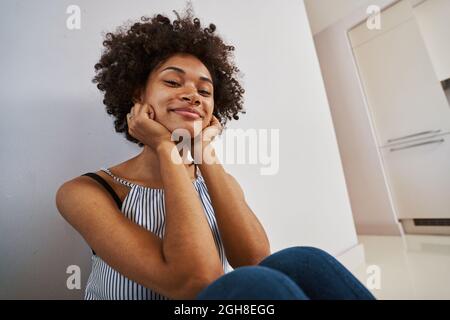 Contented tranquil woman seated on the floor Stock Photo