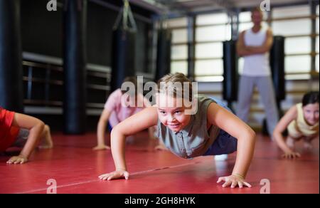 Children doing bench press exercises in the gym Stock Photo