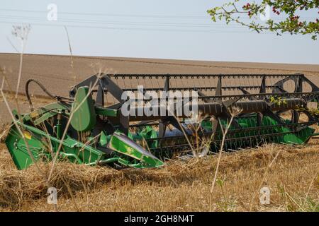 John Deere 24' harvester equipment awaiting the replacement combine on Salisbury Plain Wiltshire UK Stock Photo