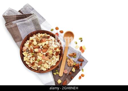 A wooden bowl  Muesli with fruit and nut and a spoon isolated on white background. Healthy breakfast composition with copy space. Top view Stock Photo