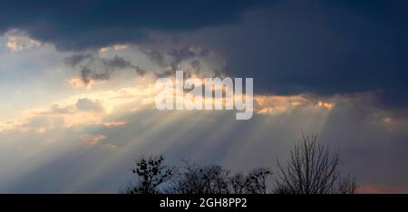 Dramatic sunset sky. Soft focus on cloud and Sunlight through the clouds at evening time. Stock Photo