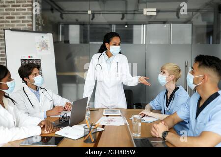 International team of doctors in face masks having medical conference Stock Photo
