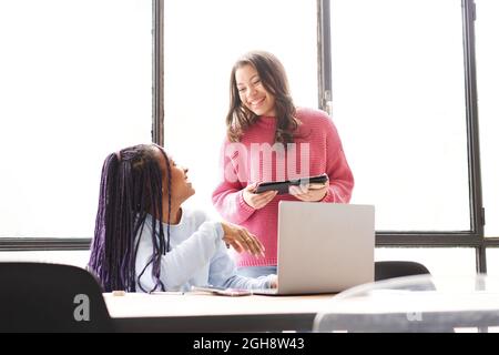 In the office: two women work together. They discuss work issues amicably while looking at the computer screen. Stock Photo