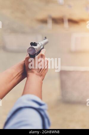 Gun in the hands of a girl, close-up arms. Stock Photo