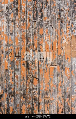 Old wooden doors with weathered peeling paintwork revealing construction - France. Stock Photo