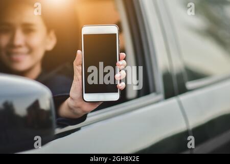 Asian  women holding smartphone in car Stock Photo