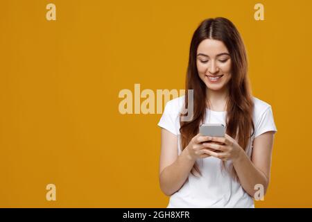 Cheerful young attractive woman holding newest cellphone Stock Photo
