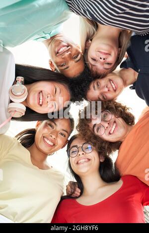 Vertical photo of a multiracial group of friends taking a selfie - New concept of normal friendship with young people looking at the camera and Stock Photo