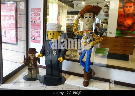 Woody in shop window Lego man cowboy  shop front hat boots jeans floor stand standing shirt chequered smile smiling pose posing friends friend doorway Stock Photo