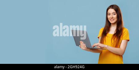 Beautiful young woman freelancer typing on laptop keyboard Stock Photo