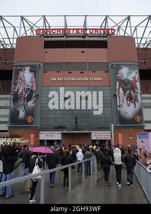 Supporters take a look at the new statue of Manchester United's manager Alex Ferguson as they arrive for the English Premier League football match between Manchester United and Swansea City at the Old Trafford Stadium in Manchester, United Kingdom on May 12, 2013. Stock Photo