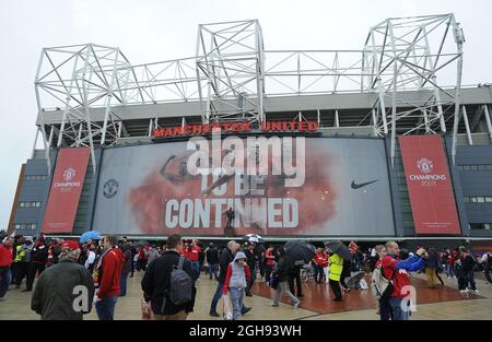 Supporters take a look at the new statue of Manchester United's manager Alex Ferguson as they arrive for the English Premier League football match between Manchester United and Swansea City at the Old Trafford Stadium in Manchester, United Kingdom on May 12, 2013. Stock Photo