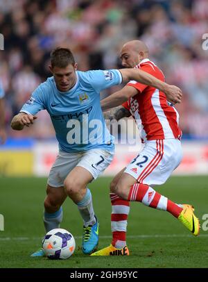 James Milner of Manchester City tackled by Stephen Ireland of Stoke City during the Barclays Premier League match between Stoke City and Manchester City held at the Britannia stadium in Stoke on Trent, UK on September 14th 2013. Photograph Simon Bellis. Stock Photo