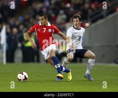 England's Leighton Baines tussles with Chile's Alexis Sanchez during the International Friendly match between England and Chile held at the Wembley Stadium in London, England on Nov. 15, 2013. Stock Photo