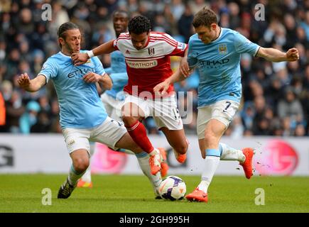 Kieran Richardson of Fulham halted by Martin Demichelis of Manchester City and James Milner of Manchester City during Barclays Premier League match between Manchester City and Fulham held at Etihad Stadium in Manchester, England on March 22, 2014. Pic Simon Bellis Stock Photo