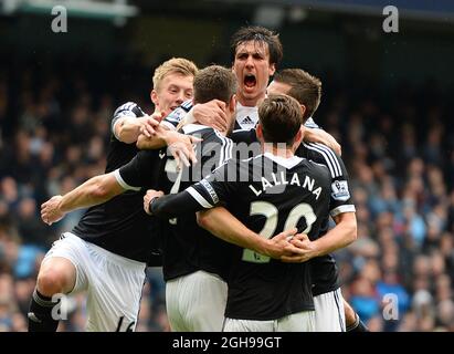 Rickie Lambert of Southampton is mobbed after scoring the equalising goal during the Barclays Premier League match between Manchester City and Southampton held at the Etihad Stadium in Manchester, England on April 5, 2014. Stock Photo
