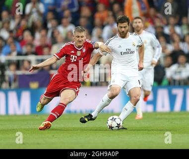 Real Madrid's Xabi Alonso tussles with Munich's Bastian Schweinsteiger during their UEFA Champion League semi-final first leg soccer match between Real Madrid and Bayern Munich at Santiago Bernabeu in Madrid, Spain on April 23, 2014. Pic David Klein Stock Photo