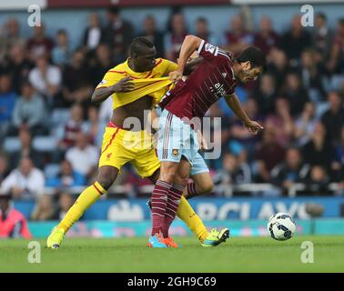 West Ham United's James Tomkins tussles with Liverpool's Mario Balotelli during the Barclays Premier League match between West Ham United and Liverpool held at the Upton Park in London, England on September 20, 2014. Stock Photo