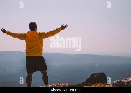 silhouette man raising hands on the mountain in the morning with vintage light Stock Photo