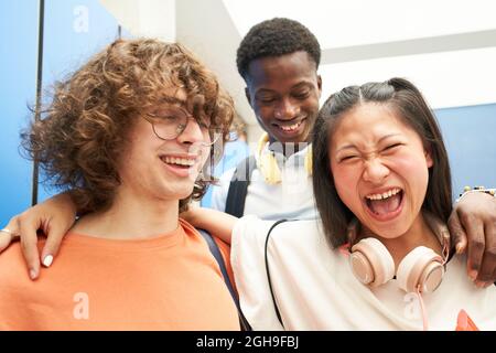 Portrait of three multiracial students looking at the camera smiling at a high school. Stock Photo