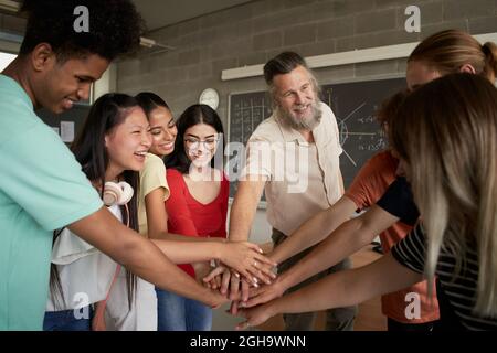 Group of students Teamwork with a teacher. Stacking Hand Concept. Stock Photo