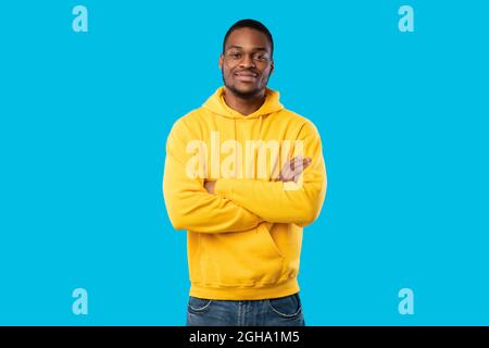 Handsome Black Millennial Man Crossing Hands Posing On Blue Background Stock Photo