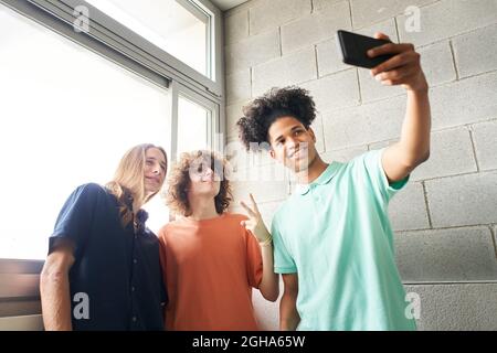 Young students taking a selfie at school. Enjoying together very different young people. Stock Photo