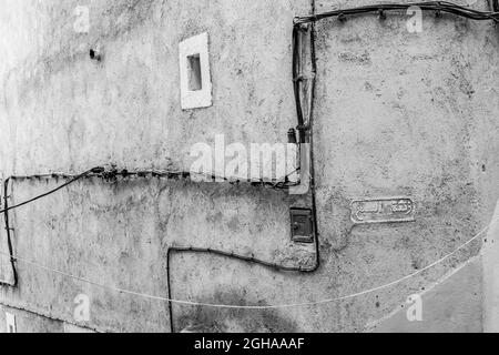 CHEFCHAOUEN, MOROCCO - Sep 01, 2018: Wires and cables attached to a wall in a narrow street of blue-washed buildings in the medina old town of Chefcha Stock Photo